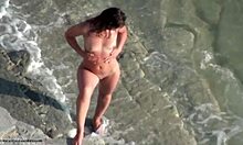 厚实的棕发女郎在裸体海滩上走来走去,全身赤裸
